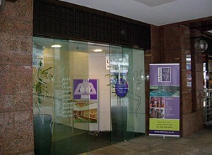Showing automatic glass doors and bronze façade.