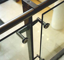 Forged and machined stainless steel uprights and handrail with toughened glass balustrade panels.