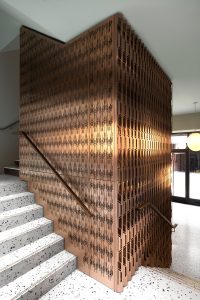 Laser-cut, V-grooved and folded PVD coloured stainless steel forming interior cladding around lift shaft. The Gaslight Building, 29 – 35 Rathbone Street, London - Developer I.S.A Holdings - Interior architecture and design: bureau de change design office - Architects: dMFK Architects - Laser-cut PVD coloured stainless steel in custom Bronze Hairline for stairs, lift core and architectural detailing by Double Stone Steel in partnership with John Desmond Ltd. - Photography by Gilbert McCarragher