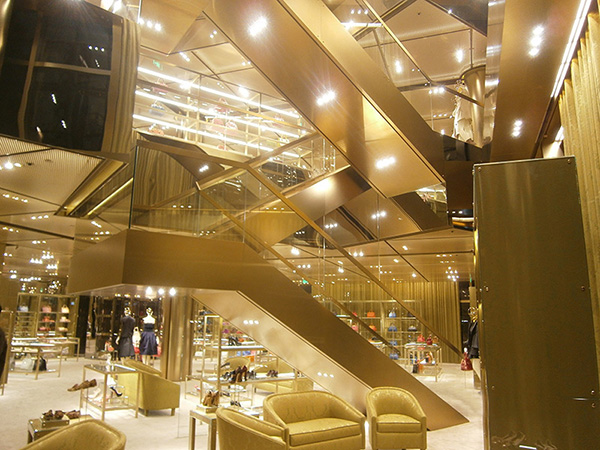 Interior of Miu Miu flagship store in Beijing. Panels and ceiling finished in PVD coated coloured stainless steel champagne SS04 4 brushed. - Architect Roberto Bachiocci