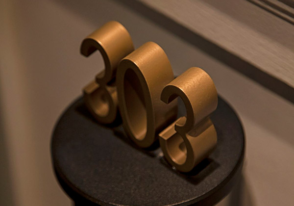 Copper room numbers on steel brackets at the Hôtel Vernet