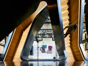 The rough-hewn timber treads – contrasting with the steel very much like the rough interior of a nut with a highly polished shell. Google offices, 6 Pancras Square, London, UK Photography by Tim Soar