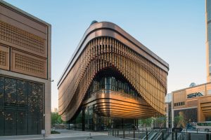 The exuberant Shanghai Bund Arts and Cultural Centre in context with the surrounding buildings with the evening sun reflecting from the detailing in PVD stainless steel in Rose Gold Vibration. Architects: Foster & Partners; Heatherwick Studio PVD: John Desmond Ltd, Photography by Tim Franco.