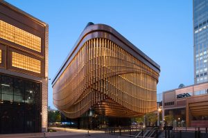 The elegant moving veil of the Shanghai Bund Arts and Cultural Centre in context with the surrounding buildings. Architectural detailing fabricated from PVD stainless steel in Rose Gold Vibration. Architects: Foster & Partners; Heatherwick Studio PVD: John Desmond Ltd, Photography by Tim Franco.