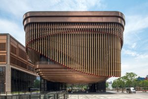 The façade of the Shanghai Bund Arts and Cultural Centre with a view towards Pudong. Fabricated from PVD stainless steel in Rose Gold Vibration. Architects: Foster & Partners; Heatherwick Studio PVD: John Desmond Ltd, Photography by Tim Franco.