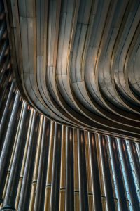 A view of the moving veil of tubes looking up at the undulating ceiling detail at the Shanghai Bund Arts and Cultural Centre. Fabricated from PVD stainless steel in Rose Gold Vibration. Architects: Foster & Partners; Heatherwick Studio PVD: John Desmond Ltd, Photography by Tim Franco.