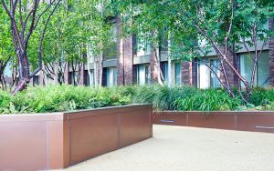Planters in Bronze sandblasted PVD stainless steel in Embassy Gardens, part of the Ballymore Homes development, Nine Elms, Wandsworth, London, UK - Landscape Architect: Camlins; Hyland Edgar Driver - Landscape Designers: In-Ex Landscapes