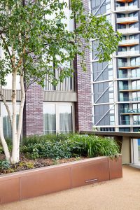 PVD coloured stainless steel in sandblasted Bronze which was specified to enhance the tones of the building materials. Embassy Gardens, London, UK.