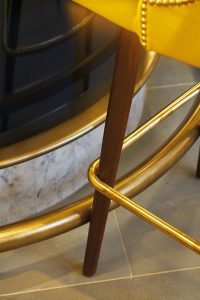 Detail of the bar rail in the Brasserie. - The Devonshire Club Hotel - Interior Design: March & White - PVD coloured stainless steel: John Desmond Ltd