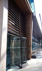 Entrance from Fetter Lane. 15 Fetter Lane, EC4A, London. PVD coloured stainless steel Brise soleil, canopy and column. John Desmond Ltd.