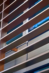 Detail of the V-grooved hollow fins. - 15 Fetter Lane, EC4A, London. - Bronze PVD coloured textured stainless steel in Chocolate for Brise soleil, canopy and column. - Architectural metalworks and PVD by John Desmond Ltd.