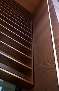 Detail of the V-grooved hollow fins and column. - 15 Fetter Lane, EC4A, London. - Bronze PVD coloured textured stainless steel in Chocolate for Brise soleil, canopy and column. - Architectural metalworks and PVD by John Desmond Ltd.