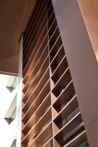 Looking up at the V-grooved, hollow canopy. - 15 Fetter Lane, EC4A, London. - Bronze PVD coloured textured stainless steel in Chocolate for Brise soleil, canopy and column. - Architectural metalworks and PVD by John Desmond Ltd.