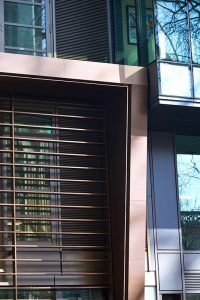 The canopy and column V-grooved from PVD stainless steel in Chocolate, giving the appearance of solid bronze. - 15 Fetter Lane, EC4A, London. - Bronze PVD coloured textured stainless steel in Chocolate for Brise soleil, canopy and column. - Architectural metalworks and PVD by John Desmond Ltd.