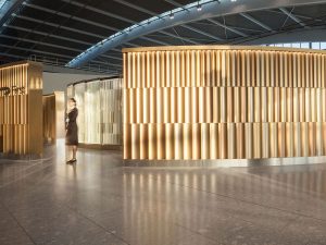 Undulating 3 metre high screen in Chocolate, Champagne and Almond Gold PVD coloured stainless steel forms entrance to British Airways Private Check-In, Heathrow Terminal 5, London. - Architects/Interior Designers: Universal Design Studio - PVD Coloured Stainless Steel: Double Stone Steel Europe Ltd - Photography: Paul Greenleaf