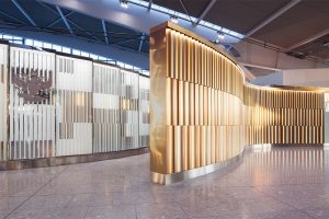 Undulating 3 metre high screen in Chocolate, Champagne and Almond Gold PVD coloured stainless steel creates a Brand Statement for British Airways Private Check-In, Heathrow Terminal 5, London. - Architects/Interior Designers: Universal Design Studio - PVD Coloured Stainless Steel: Double Stone Steel Europe Ltd - Photography: Paul Greenleaf