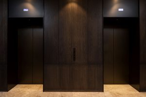 A smart, streamlined and durable elevator lobby. - Elevator architrave and panels in V-Grooved PVD coloured stainless steel in Chocolate Vibration. Fenman House, Apartment Building, 9 Handyside St, King’s Cross, London N1C. - Fabrication, V-Grooving and folding of stainless steel by John Desmond Ltd.