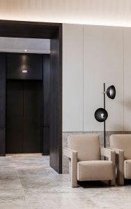 The Bronze tones of the elevator lobby are harmonious with the colours and finishes in the reception area. - Elevator architrave and panels in V-Grooved PVD coloured stainless steel in Chocolate Vibration. Fenman House, Apartment Building, 9 Handyside St, King’s Cross, London N1C. - Fabrication, V-Grooving and folding of stainless steel by John Desmond Ltd.