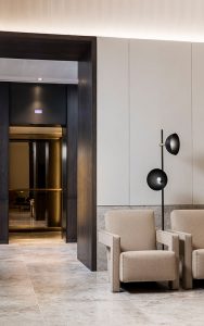 The warm lighting within the elevator cabs creates a welcoming feel from the reception area. - Elevator architrave and panels in V-Grooved PVD coloured stainless steel in Chocolate Vibration. Fenman House, Apartment Building, 9 Handyside St, King’s Cross, London N1C. - Fabrication, V-Grooving and folding of stainless steel by John Desmond Ltd.