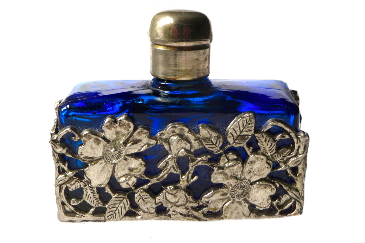 Glass Perfume Bottle – Cobalt Blue in White Metal Sleeve from Vee’s Collectable, Antique & Vintage Emporium. Adding cobalt to glass gives it a distinctive blue tint and is highly collectible.