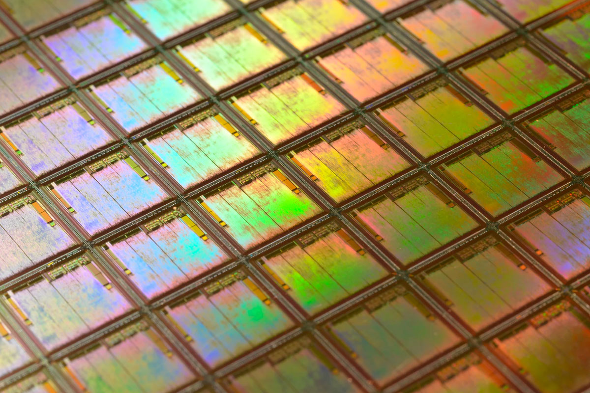 Close-up shot of a silicon wafer. Each square is a chip with microscopic transistors and circuits which goes into the processors that power our phones and computers.