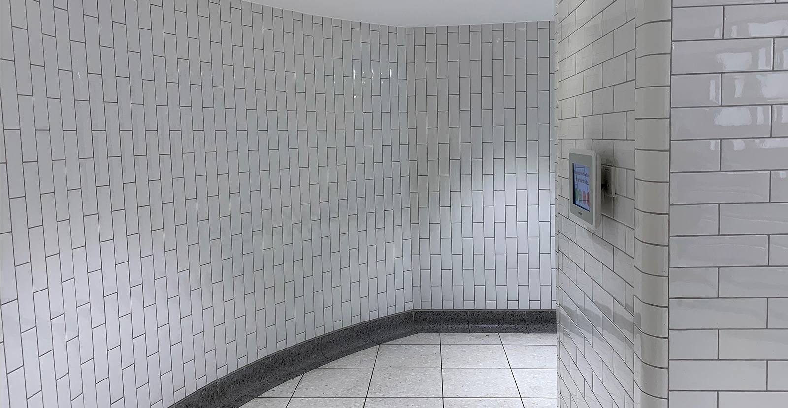 Subway tiles give the feeling of an underground station, while also providing a robust surface. London Victoria Rail Station WC. - Architects Landolt + Brown. Fit out contractor Maxwood Washrooms.