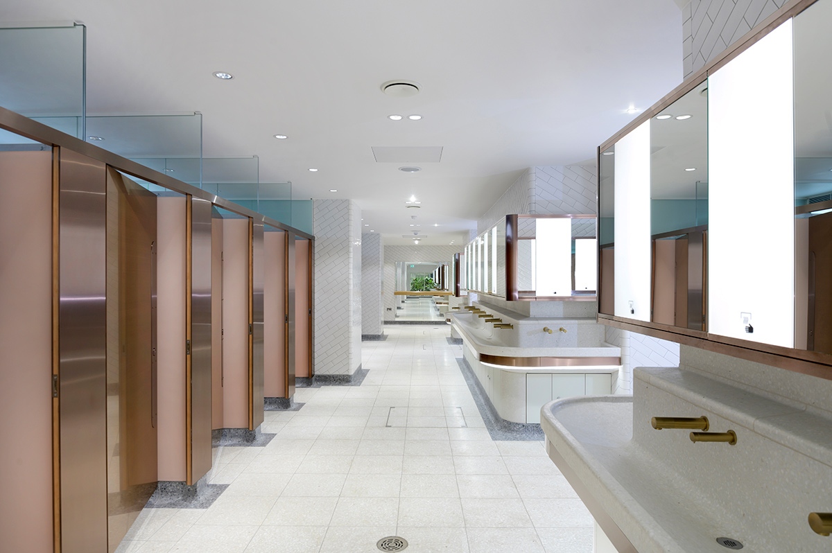 Visual for upgrade of WCs Victoria Station, London showing white, bronze and copper colour palette with indoor courtyard shown at the far end.  Client: Network Rail Architects: Landolt + Brown Fitout: Maxwood Washrooms PVD coloured stainless steel by Double Stone Steel Architectural metalwork by John Desmond Ltd