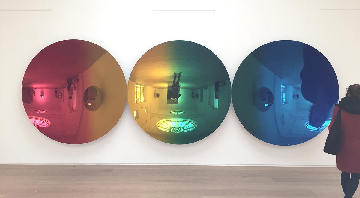In Anish Kapoor’s  Red to Blue (2016) stainless steel discs reflect distorted and inverted images of visitors as they move through the colour spectrum. Photograph by Stefan Tribe