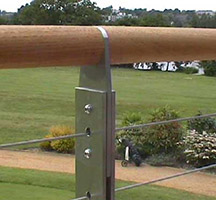 External balcony with tensioned cable balustrades incorporating straining wires fixed with bottle screws and teak handrail.