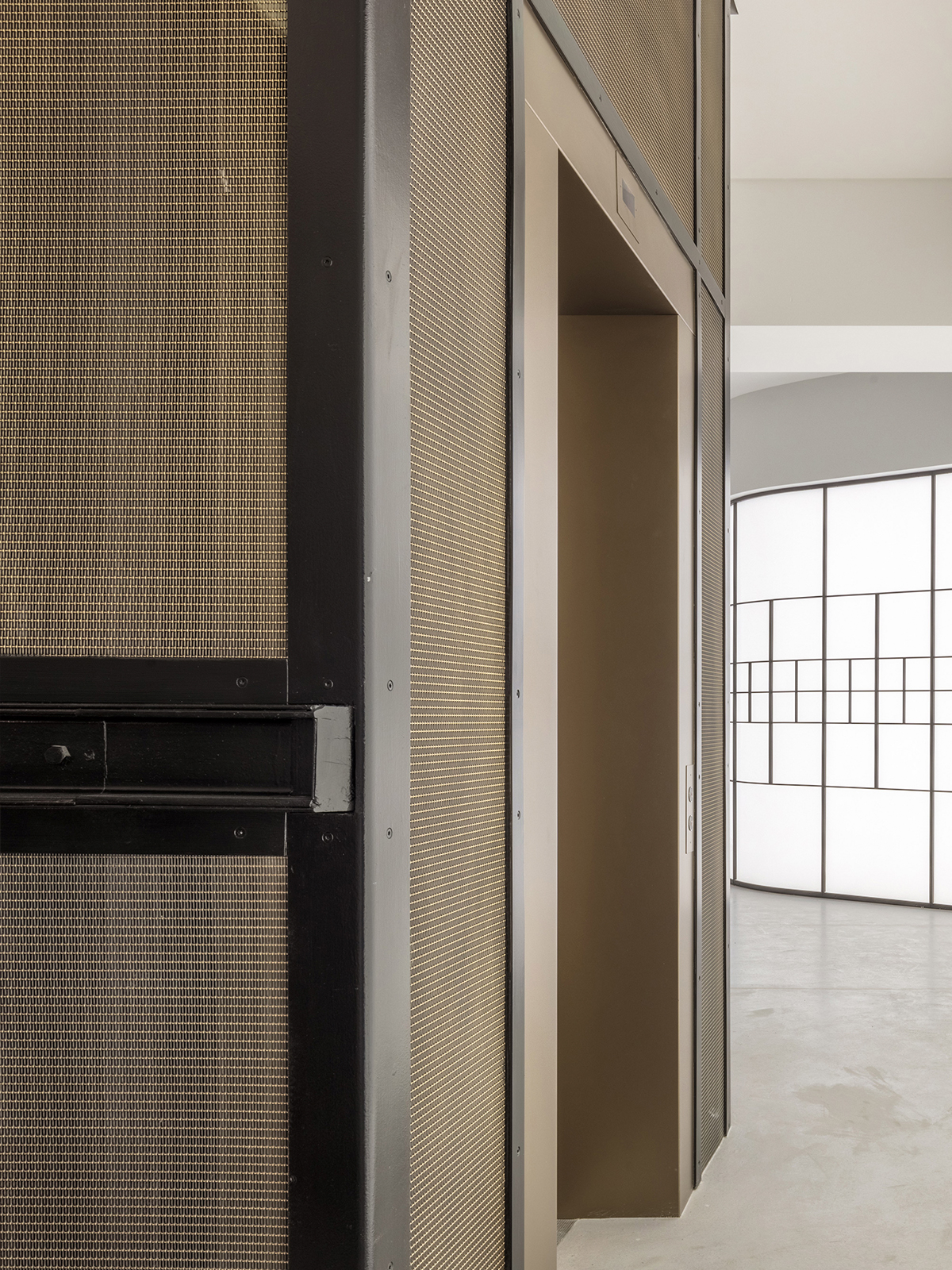 Minerva House, 26 Hatton Garden, Holborn, London. - Showing lift shaft clad in Amron Architectural mesh LPZ-71 in Antique Brass fixed within Bronze PVD panel frames.