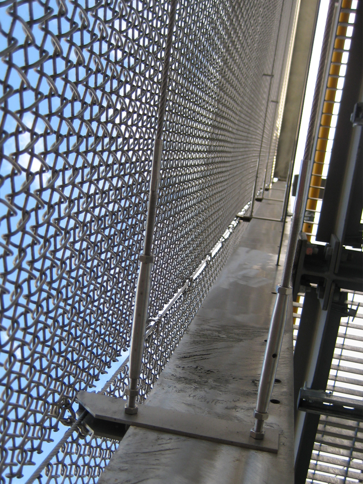 Wood Lane underground station. - Showing mesh tautened with tension fixings as part of the full-height safety balustrade to maintenance walkway. - Created in Amron Spiral mesh Alpine 12 in stainless steel.