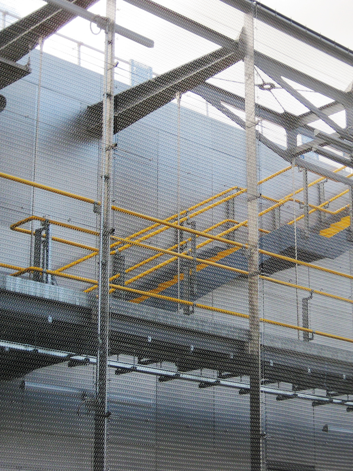 Wood Lane underground station. - Showing tensioned mesh forming a full-height safety balustrade to maintenance walkway and stairs. - Created in Amron Spiral mesh Alpine 12 in stainless steel.