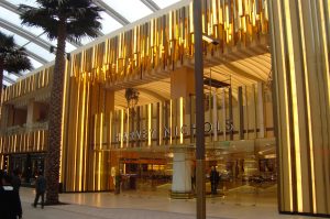 Harvey Nichols retail department store, The Avenues, Kuwait. - Undulating façade, columns and detailing in Double Stone Steel PVD colored stainless steel Royal Gold Mirror. - Client: Four IV Interior Design - Architect: Gensler - Developer: Mabanee