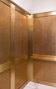 Architectural mesh elevator cab shell walls in bronze. - 166 Geary Street, The Grace Building, San Francisco - Project Designer: Unique Elevator Interiors - Architectural mesh: Banker Wire
