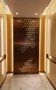Elevator cab with laser-cut PVD stainless steel backlit panel in PVD coloured stainless steel Bronze Vibration, side panels in Champagne Vibration and handrail inset section in Bronze Vibration. - Guangzhou Infinitus Plaza Building - Architecture and design: Zaha Hadid Architects - PVD coloured stainless steel by Double Stone Steel in partnership with John Desmond Ltd.