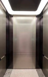Elevator cab with vertical curved radius corner sections in PVD coloured stainless steel Chocolate Vibration and wall panels in PVD coloured stainless steel Nickel Vibration. Rear wall panel has shadow-gap detailing created by V-grooving. - Hongqi headquarters, Changchun, Jilin , China - Architecture: Woods Bagot - PVD coloured stainless steel by Double Stone Steel in partnership with John Desmond Ltd.