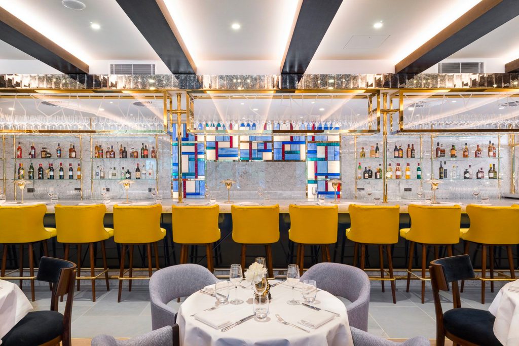 The Brasserie bar in the Devonshire Club Hotel with overhead glass rack in brass PVD coloured stainless steel.The Devonshire Club Hotel, Interior Design: March & White, PVD coloured stainless steel: John Desmond Ltd